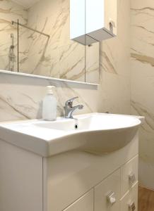 a bathroom with a white sink and a mirror at Miami Apartments in St. Julianʼs