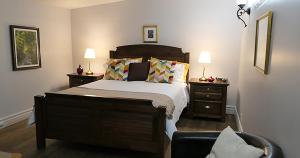 - une chambre avec un lit, 2 tables de nuit et 2 lampes dans l'établissement Auberge La Daïna, à Baie-Saint-Paul