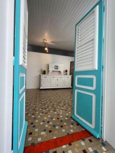 a blue door in a room with a kitchen at Case Louis et spa in Saint-Pierre
