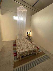 1 dormitorio con 1 cama con cortina en Case Louis en Saint-Pierre