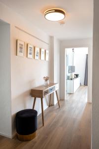 a living room with a desk and a hallway at Moderne Wohnung, citynah, mit Ausblick über die Stadt in Hannover