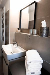 ein Badezimmer mit einem Waschbecken, einem Spiegel und Handtüchern in der Unterkunft Moderne Wohnung, citynah, mit Ausblick über die Stadt in Hannover
