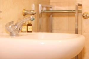 a bathroom sink with a shower and two bottles of soap at Star London Golders Rise Luxury 4-Bed Oasis with Garden in Hendon
