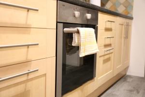 a kitchen with an oven with a towel on it at Star London Golders Rise Luxury 4-Bed Oasis with Garden in Hendon