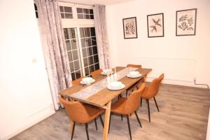 a dining room with a wooden table and chairs at Star London Golders Rise Luxury 4-Bed Oasis with Garden in Hendon +43 photos
