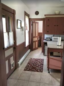 a kitchen with a door and a table and a rug at Charming home in the heart of Rockland 