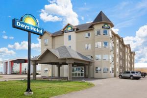 a hotel with a street sign in front of it at Days Inn by Wyndham Bonnyville in Bonnyville