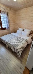 ein Schlafzimmer mit einem großen Bett in einem Holzzimmer in der Unterkunft КОТТЕДЖ У МОРЯ in Tschornomorsk