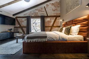 a bedroom with a large bed and a brick wall at Kurpiai - Suites & SPA in Klaipėda