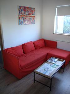 un sofá rojo en una sala de estar con mesa en Unique World War II history attached to this dwelling, en Dublín