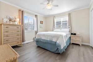 een slaapkamer met een bed en een plafondventilator bij Beach D-ehs Brunswick Vacation Rentals in Ocean Isle Beach