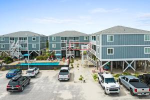 een groep appartementen met auto's geparkeerd op een parkeerplaats bij Beach D-ehs Brunswick Vacation Rentals in Ocean Isle Beach
