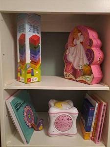 a shelf with books and a toy telephone and a book at Bilbao, a un paso. in Bilbao