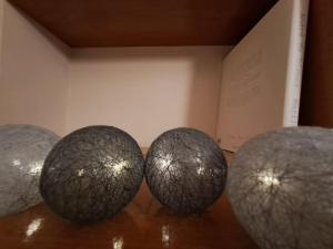 four balls sitting on a table next to a book at Bilbao, a un paso. in Bilbao