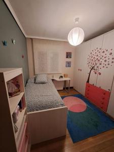 ein kleines Schlafzimmer mit einem Bett und einem Tisch in der Unterkunft Bilbao, a un paso. in Bilbao