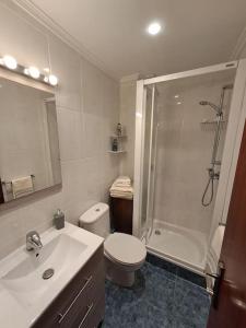 a bathroom with a toilet and a sink and a shower at Bilbao, a un paso. in Bilbao