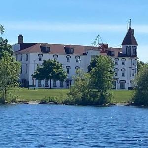 un grand bâtiment blanc à côté d'une étendue d'eau dans l'établissement Historical Hotel - House of Ludington, à Escanaba