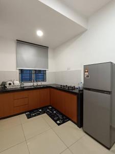 cocina con nevera de acero inoxidable y ventana en DESARU SERENITA Homestay NETFLIX WIFI, en Bandar Penawar