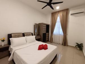 Un dormitorio con una cama con dos zapatos rojos. en DESARU SERENITA Homestay NETFLIX WIFI, en Bandar Penawar