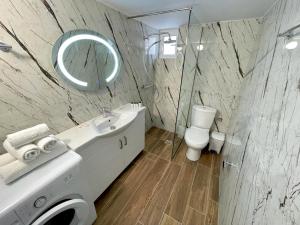a bathroom with a sink and a mirror and a toilet at Four Seasons Apartments in Ksamil