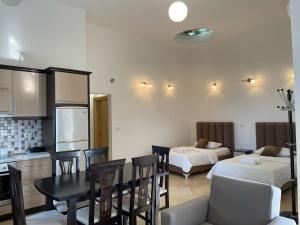cocina y sala de estar con 2 camas y mesa en Four Seasons Apartments, en Ksamil