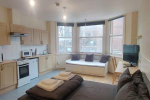 a living room with a couch and a kitchen at Very Large Studio on Finchley Road 11 in London