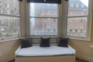 a window seat in a room with two large windows at Very Large Studio on Finchley Road 11 in London