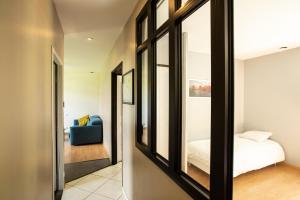 ein Schlafzimmer mit einem Spiegel, einem Bett und einem Sofa in der Unterkunft Maison calme, près du puy du fou in La Gaubretière