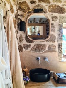 a stone bathroom with a sink and a mirror at Casa nel Bosco, un oasi di pace in Seccheto