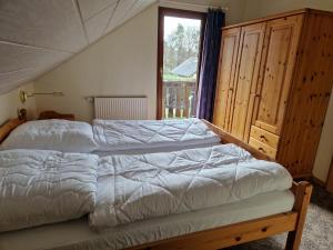 ein Schlafzimmer mit einem Bett und einem großen Fenster in der Unterkunft Ferienhaus im Seepark von Kirchheim in Kirchheim