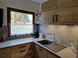 uma cozinha com um lavatório e uma janela em Ferienhaus im Seepark von Kirchheim em Kirchheim
