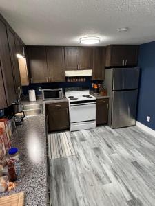 a kitchen with wooden cabinets and white appliances at Entire level just off Interstate, free breakfast in Fargo +4 photos