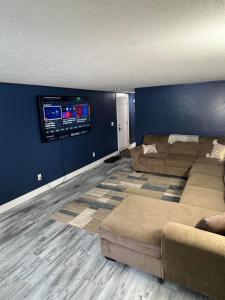 a living room with two couches and a flat screen tv at Entire level just off Interstate, free breakfast in Fargo