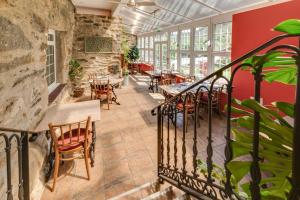 eine Terrasse mit Tischen und Stühlen in einem Restaurant in der Unterkunft Sygun Fawr Country House in Beddgelert