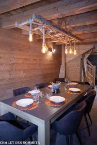 una mesa de comedor con sillas y una mesa larga con gafas en Le Chalet des Sommets à Briançon, en Puy-Saint-Pierre