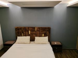 um quarto com uma cama grande e 2 almofadas em Fun Bedroom Apartment in Gold Crest Mall and Residency DHA Lahore em Lahore