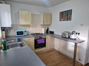 a kitchen with a sink and a stove top oven at Primos Executive - 2 Bedroom House in Wallsend in Old Walker