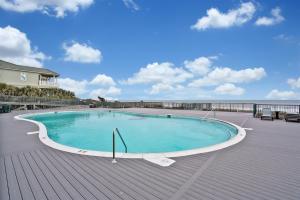 a swimming pool on a deck next to the ocean at Ain`t It The Life Brunswick Vacation Rentals in Ocean Isle Beach