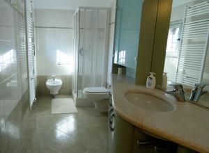 bagno con lavandino, servizi igienici e specchio di BBgreen a Pero