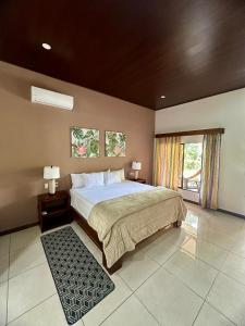 a bedroom with a large bed and two windows at Villa Tucan in Fortuna