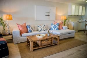a living room with a couch and a table at Skiathos at Beachfront Apartments in Shakas Rock in Ballito