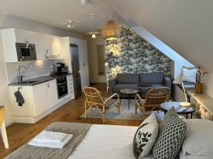a living room with a couch and a kitchen at Halmstad Gårdshotell in Halmstad