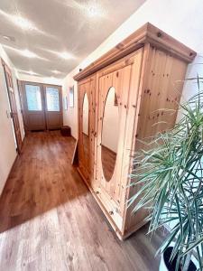 Cette chambre dispose d'une armoire en bois avec un miroir. dans l'établissement Ferienwohnung TINA, à Naumbourg
