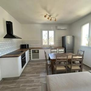 a kitchen with a table and chairs in a room at Appartement entre mer et montagne avec beau jardin in Calenzana