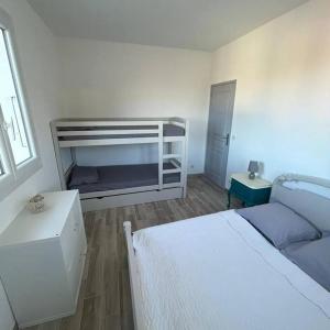 una camera da letto bianca con un letto e un divano di Appartement entre mer et montagne avec beau jardin a Calenzana