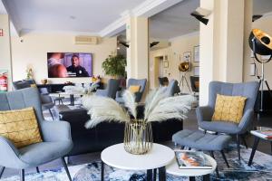 un vestíbulo con sofás y sillas y un jarrón con plumas en HOTEL SANTHYAGO TROFA en Trofa