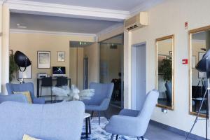een wachtkamer met blauwe stoelen en een spiegel bij HOTEL SANTHYAGO TROFA in Trofa