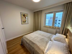 a small bedroom with a bed and a window at Bagry Apartments in Krakow