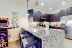 a kitchen with a granite counter top and a refrigerator at Retreat Magic in Orlando