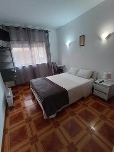 a bedroom with a large bed and a wooden floor at Residencial S. Gião in Valença